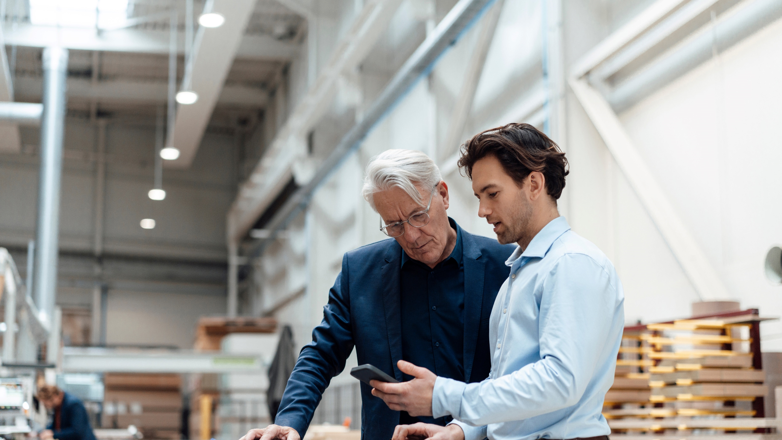 Two workers looking an a smart phone